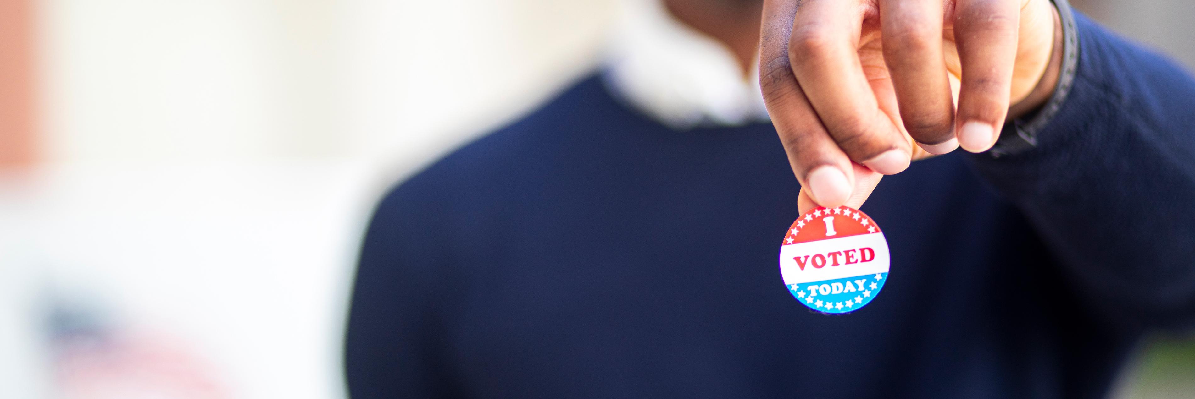 Man holding a I voted today pin