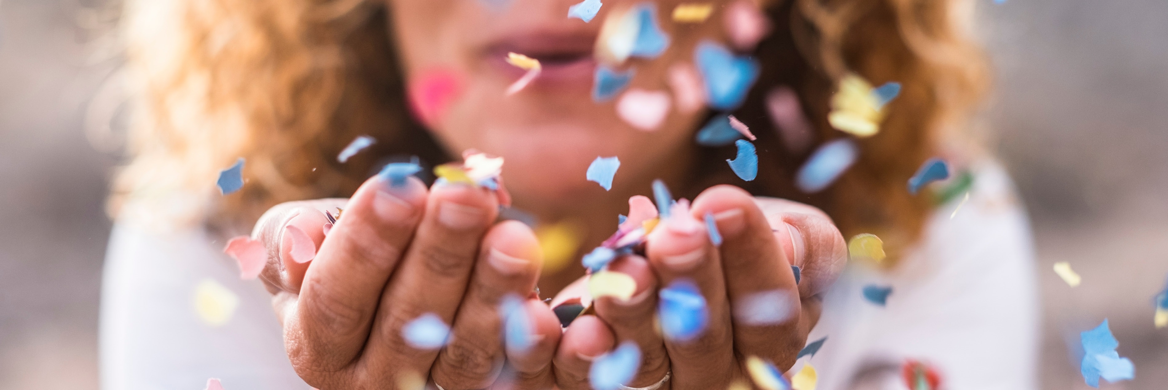 photo of person blowing confetti in their hands