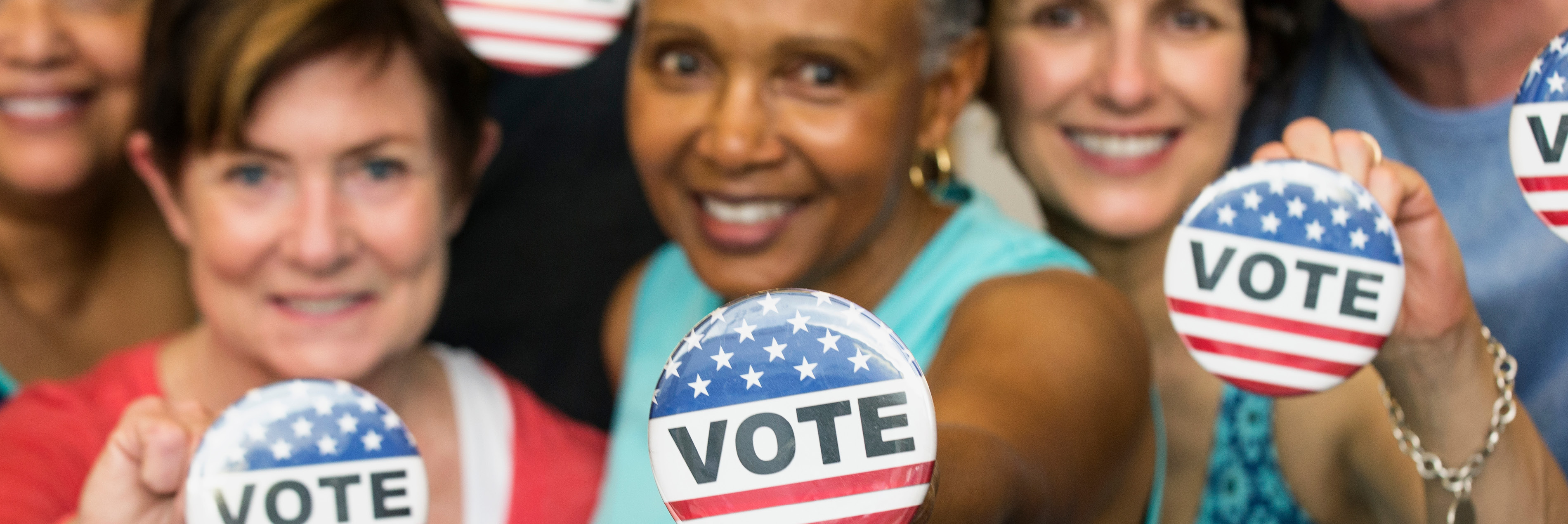 Women holding vote pins