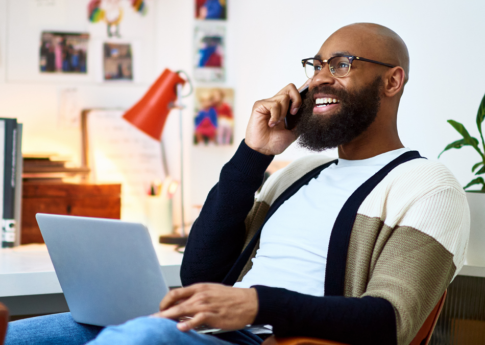 Man talking on phone with laptop in his lap