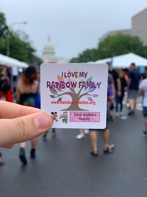 Person holding a Rainbow Families sticker