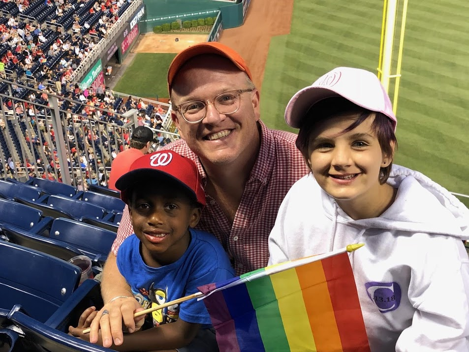 Man with two children at a baseball game