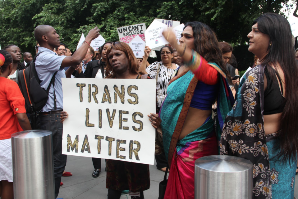 Person holding a trans lives matter sign